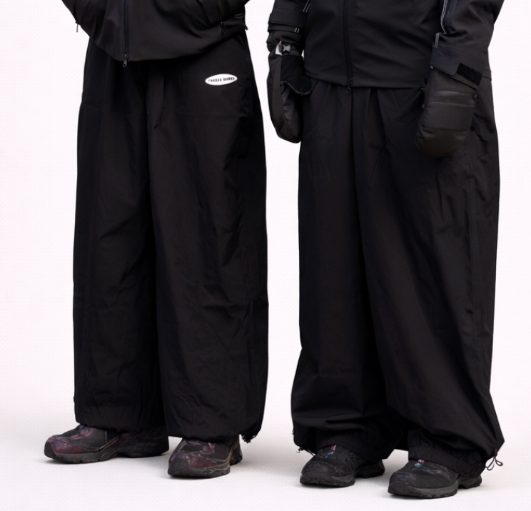 Two people wearing black snowmobile suits on a white background